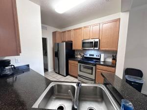 uma cozinha com um lavatório e um frigorífico de aço inoxidável em Private 1/1 Unit in Sanford, FL em Sanford