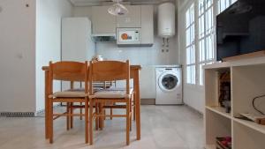 een keuken met een tafel en stoelen en een wasmachine bij Apartamento La Barrosa - Chiclana - Urb. Pinar Atlántico in Chiclana de la Frontera