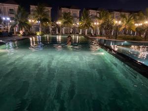 a woman in a swimming pool at night at CĂN HỘ VINHOMES GRAND PARK QUẬN 9 in Gò Công