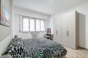 1 dormitorio con 1 cama con edredón blanco y negro en Roomy Apartment Close to Siena Center!, en Siena