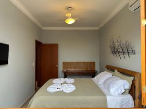 a bedroom with a bed with towels on it at Pousada Maria Monteiro Tiradentes in Tiradentes