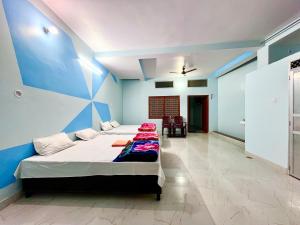 a bedroom with two beds and a blue wall at Trilok Residency - Dashashwamedh Varanasi in Varanasi