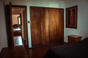 una camera da letto con armadio e armadietto in legno di El patio de Malek a Cosquín