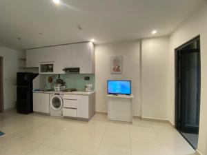 a kitchen with a tv and a washing machine at CĂN HỘ VINHOMES GRAND PARK QUẬN 9 in Gò Công