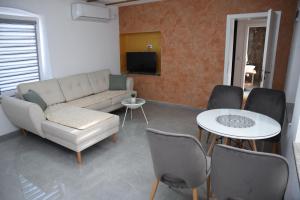 a living room with a couch and a table and chairs at Rooms Filip in Bitola