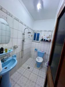 a bathroom with a blue toilet and a sink at Mini villa cosy et discrete in Douala