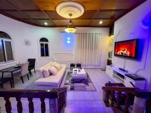a living room with a couch and a tv at Mini villa cosy et discrete in Douala