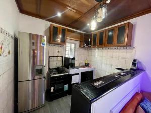 a kitchen with a black counter and a refrigerator at Mini villa cosy et discrete in Douala