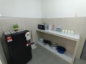 a small kitchen with a black refrigerator and a shelf at Dream 5 @ Emerald avenue in Brinchang