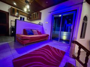 a bedroom with a bed with purple lighting at Mini villa cosy et discrete in Douala