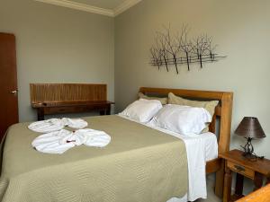 a bedroom with a bed with towels on it at Pousada Maria Monteiro Tiradentes in Tiradentes