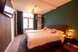een slaapkamer met een bed met twee teddyberen erop bij Hotel Bom in Burgh Haamstede