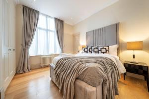 a bedroom with a large bed and a large window at Beautiful 2-Bedroom Apartment in Mayfair in London