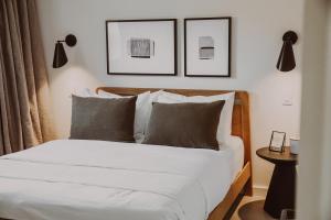 1 dormitorio con 1 cama con sábanas y almohadas blancas en The Colby House - Downtown Kingston en Kingston