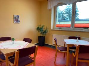 a room with two tables and chairs and a window at Pension Leyerhof in Wendisch Baggendorf