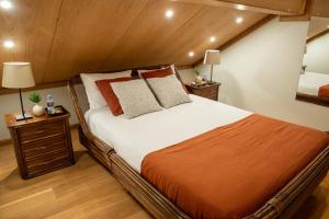 a large bed in a room with wooden ceilings at Casas do Souto in Lousada