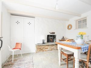 a kitchen with a table and a fireplace at Cobb Cottage in St Austell