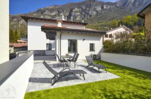 a patio with chairs and a table and a house at FORESTERIA GUESTHOUSE CA' DEI BACHITT in Lierna