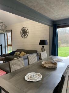 a living room with a table and a couch at cottage chaleureux dans domaine privé in Signy-le-Petit