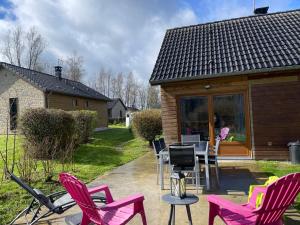 une terrasse avec des chaises et une table ainsi qu'une maison dans l'établissement cottage chaleureux dans domaine privé, à Signy-le-Petit