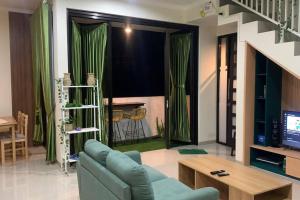 a living room with a blue couch and a tv at AdyneVille in Malang