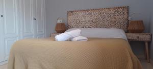 a bedroom with a bed with two towels on it at CHALET Cubo de las Monjas in Nava del Rey