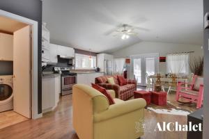 a kitchen and living room with a couch and chairs at Un coin pour deux in Saint-Raymond