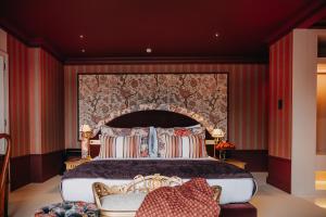 een slaapkamer met een groot bed en een rode muur bij Vinha Boutique Hotel - The Leading Hotels of the World in Vila Nova de Gaia