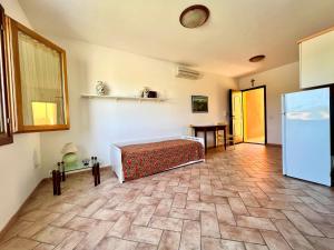 サンタ・テレーザ・ガッルーラにあるPretty garden houseのベッドとテーブルが備わる部屋