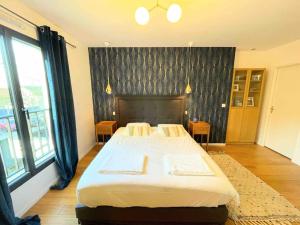 1 dormitorio con cama grande y ventana grande en Maison moderne et confortable en bordure de forêt, en Poissy