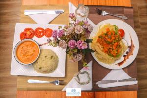 a table with two plates of food and a bowl of soup at Harmony Spot Hotel in Marsabit