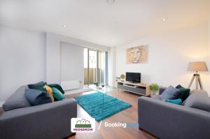 una sala de estar con 2 sofás y una alfombra verde en Deluxe 2 Bed 2 Bath Manchester City Centre Apartment By Hedgerow Properties Limited en Mánchester
