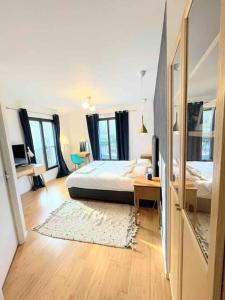 1 dormitorio con cama, mesa y ventanas en Maison moderne et confortable en bordure de forêt, en Poissy