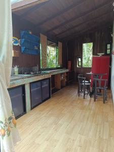 uma cozinha com pisos em madeira, uma mesa e cadeiras em Chalé Beija Flor em Porto Belo