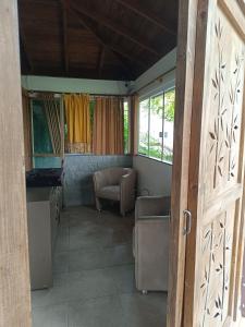 um quarto com uma sala de estar com uma mesa e cadeiras em Chalé Beija Flor em Porto Belo