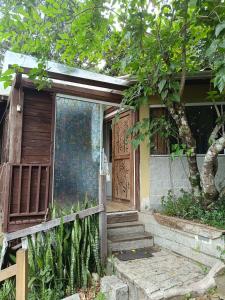 a house with a wooden door and some trees at Chalé Beija Flor in Porto Belo