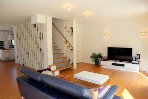 sala de estar con sofá y TV en Maison moderne et confortable en bordure de forêt, en Poissy