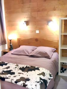 een slaapkamer met een bed met een houten muur bij Appartement charmant à Avoriaz - Vue montagnarde - 26 m² in Avoriaz