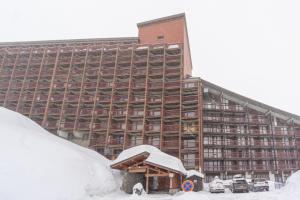 a large building with snow in front of it at Arc 2000 appartement type chalet in Bourg-Saint-Maurice