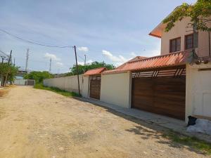 プラヤスにあるPlayasの二戸のガレージドアと未舗装の道路のある家