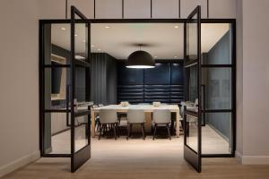 a dining room with a table and white chairs at Sheraton Fort Worth Downtown Hotel in Fort Worth