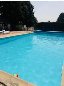 a large swimming pool with blue water at Le chalet de Blonville in Blonville-sur-Mer