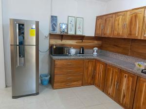 eine Küche mit Holzschränken und einem Kühlschrank aus Edelstahl in der Unterkunft Playas in Playas