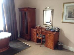a bathroom with a wooden desk and a mirror at The Villa Levens in Levens