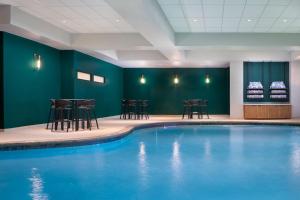 - une piscine dans une pièce avec des chaises et des tables dans l'établissement Sheraton Fort Worth Downtown Hotel, à Fort Worth
