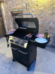 a black barbecue grill with a plate of food on it at Acogedora casa con patio-parking in Albarracín
