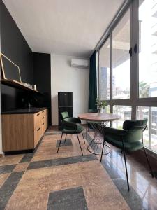 sala de estar con mesa, sillas y TV en Cactus Apartments en Durrës