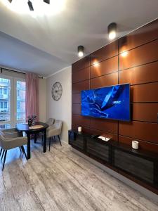 a living room with a large flat screen tv on a wall at Maya's Flats & Resorts 59 - Most Miłości in Gdańsk