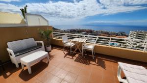 a balcony with a table and chairs and the ocean at Los Gigantes,huge terrace,sea view,air conditioning in Puerto de Santiago