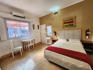 1 dormitorio con 1 cama, mesa y sillas en Jazmines Apart en Martínez